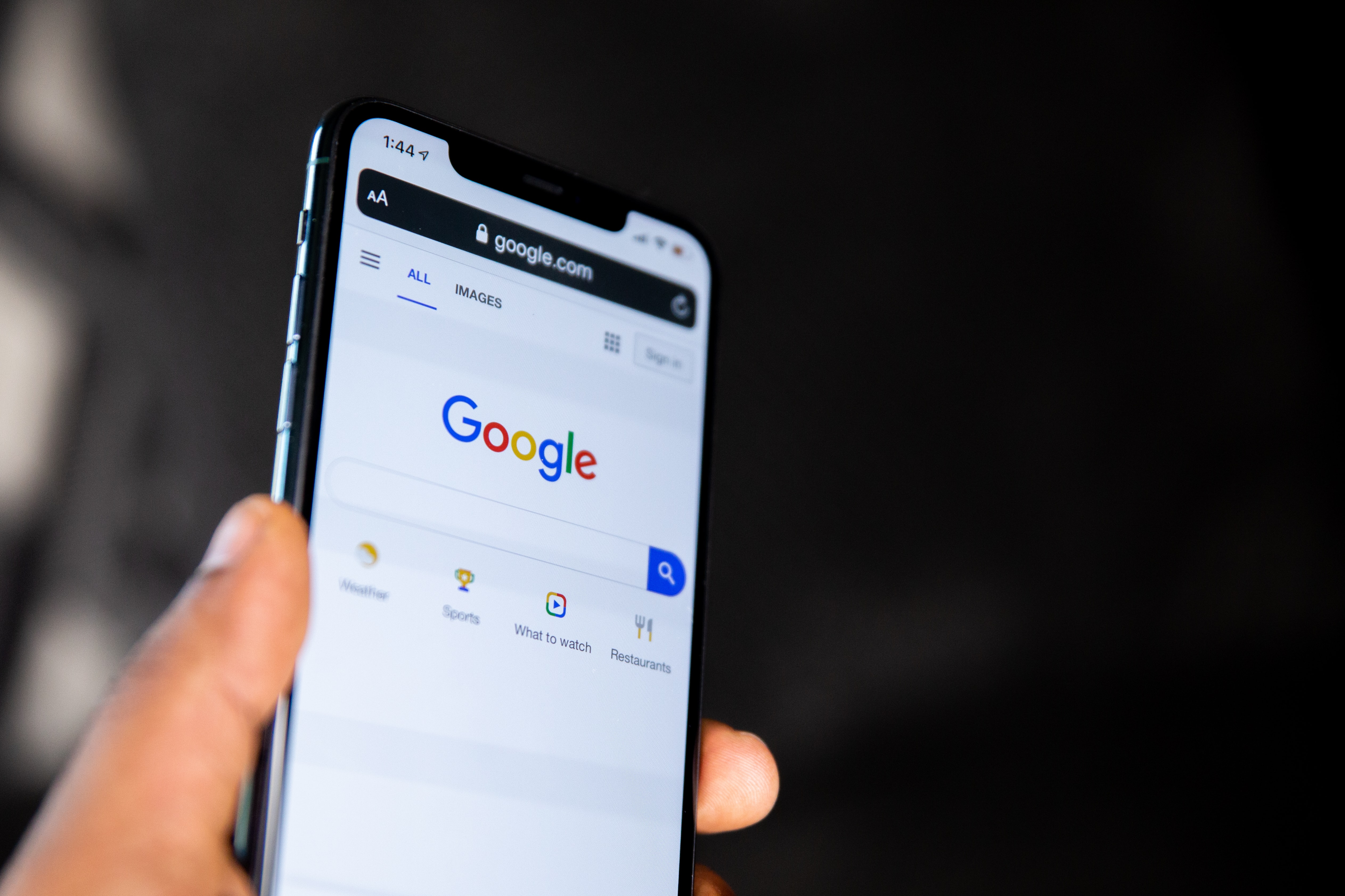 person holding phone open to google's search engine page